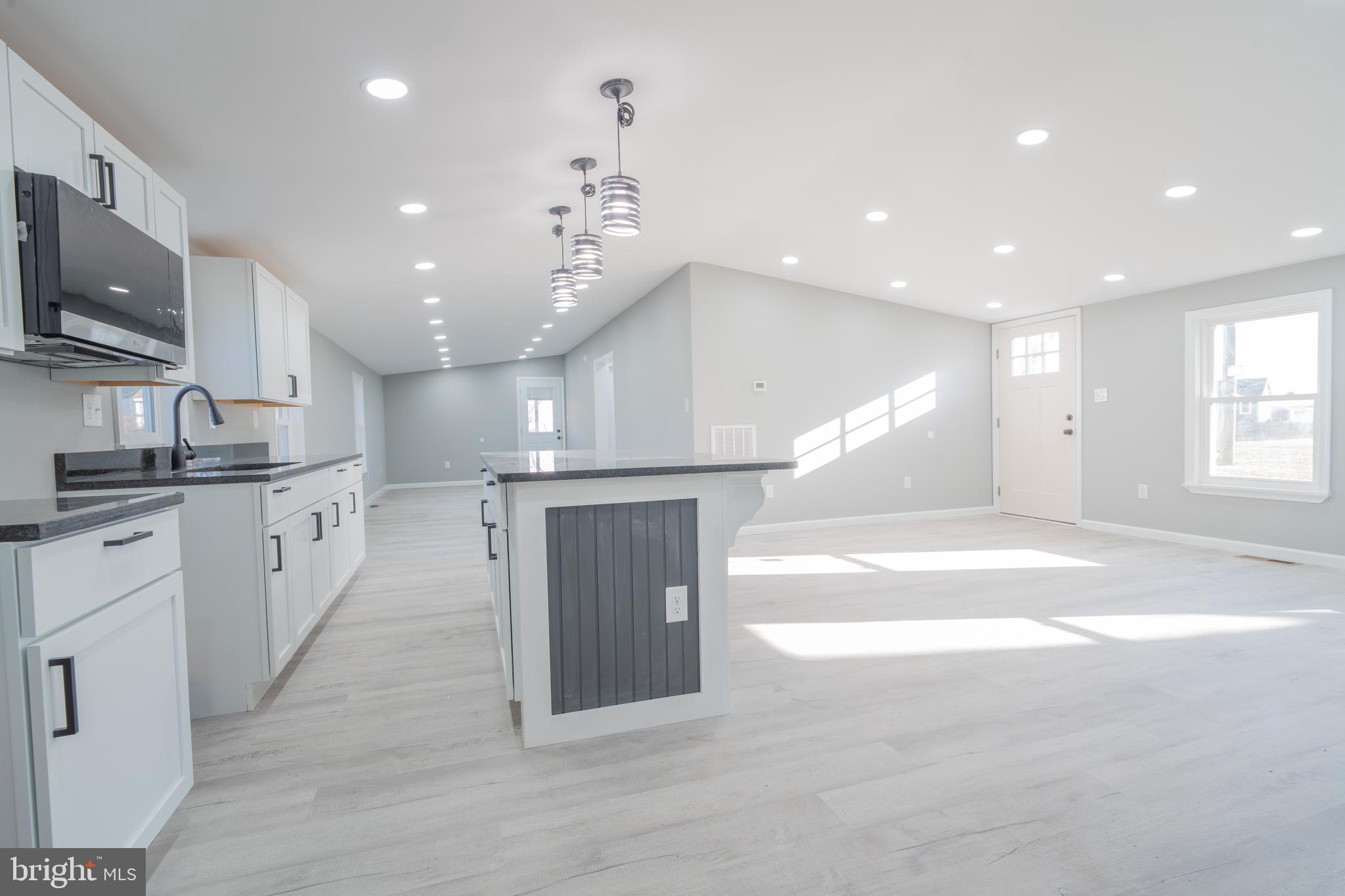 12579 Whitesville Road Laurel, DE 19956 - Photo 16 of 25 a open kitchen with kitchen island a sink dishwasher stove and white cabinets with wooden floor