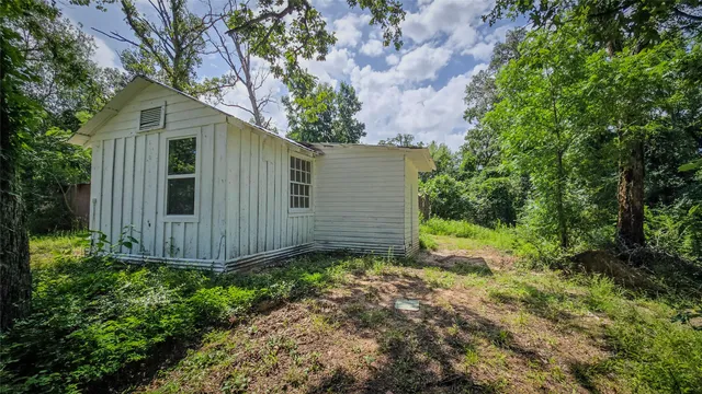 a view of a small house in the middle of a yard