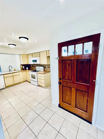 a kitchen with granite countertop a refrigerator and a stove top oven