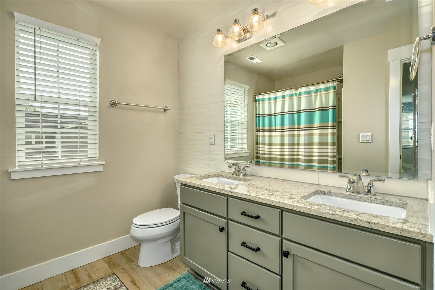 3312 238th Place Southeast Bothell, WA 98021 - Photo 16 of 40 a bathroom with a granite countertop toilet a sink a mirror and a window