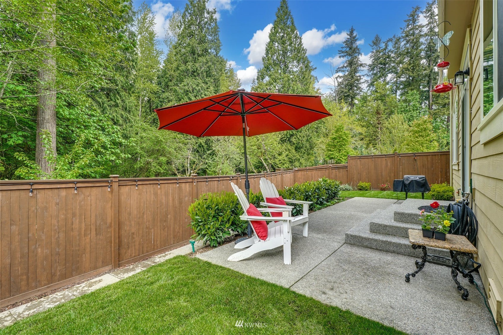 3312 238th Place Southeast Bothell, WA 98021 - Photo 31 of 40 a view of a backyard with a chair and table under an umbrella