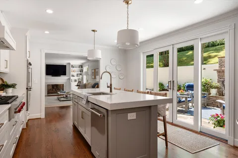 a kitchen with stainless steel appliances a stove a sink and a white cabinets