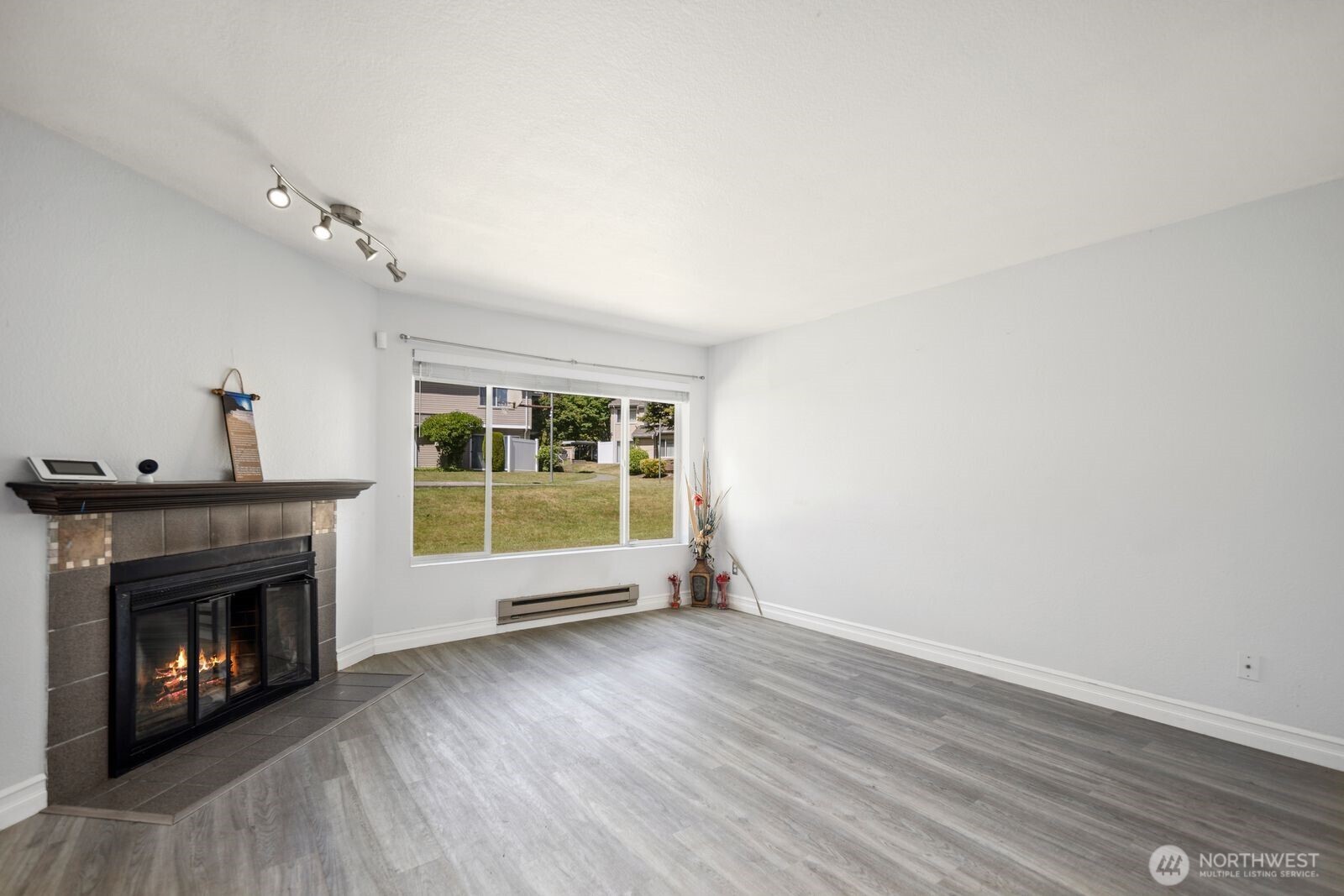 2100 South 336th Street, Unit G3 Federal Way, WA 98003 - Photo 2 of 27 a view of an empty room with wooden floor fireplace and a window