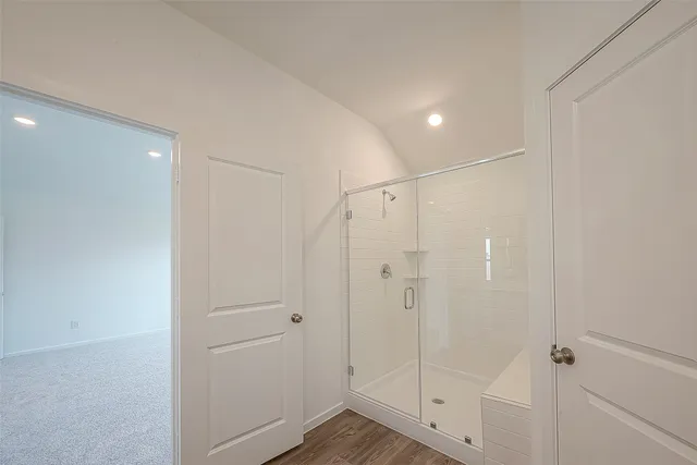 a bathroom with a shower and a glass door