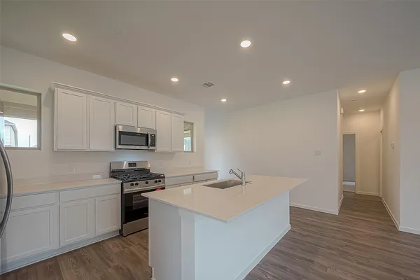 a kitchen with stainless steel appliances a sink stove and cabinets