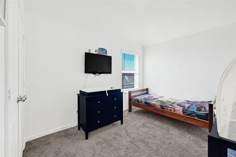 a bed sitting in a bedroom next to a window