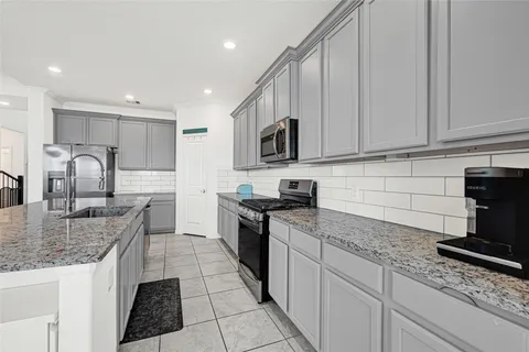 a kitchen with stainless steel appliances granite countertop a sink stove and cabinets