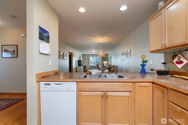 a room with stainless steel appliances kitchen island granite countertop a sink and cabinets