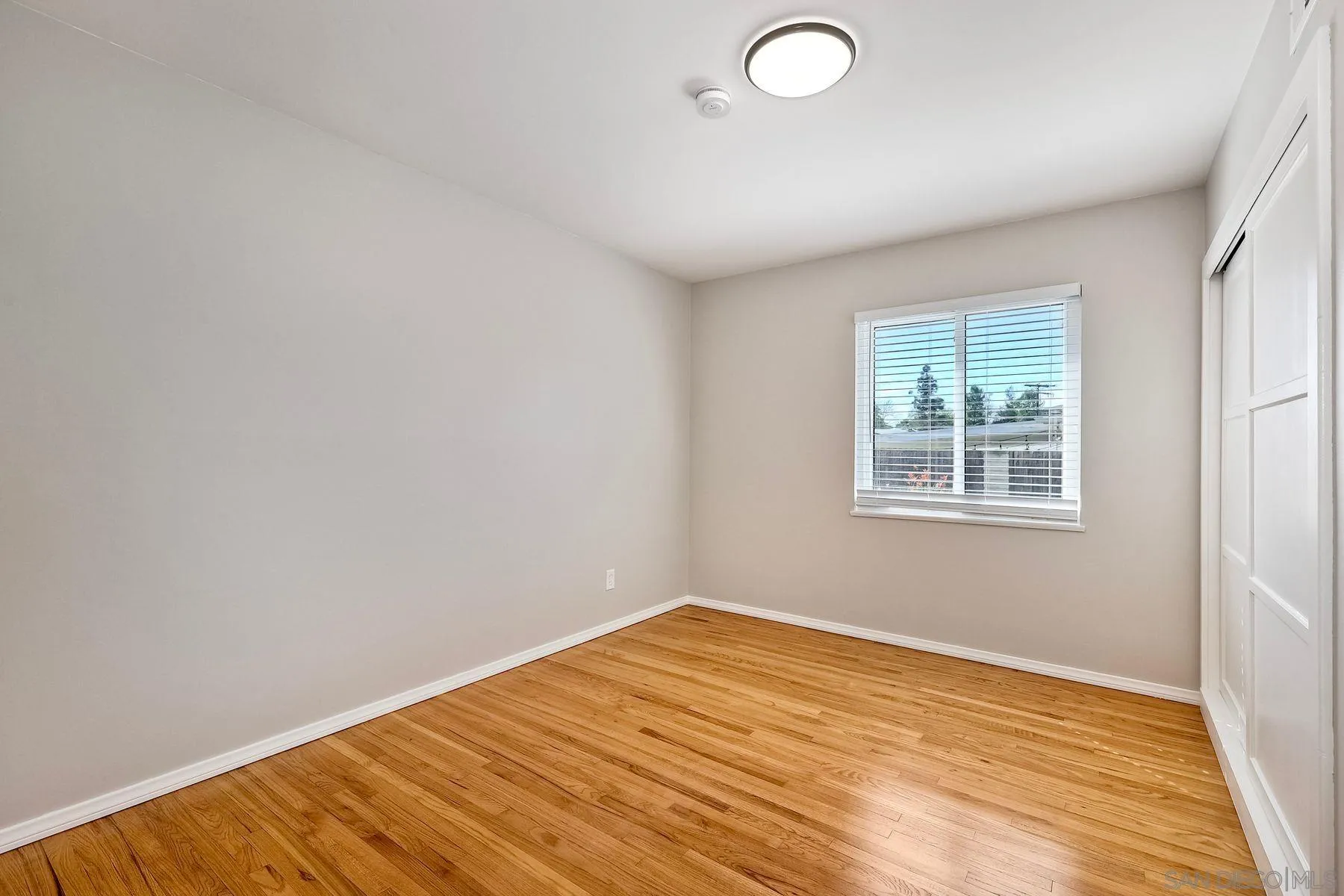 9307 Manor Drive La Mesa, CA 91942 - Photo 12 of 29 an empty room with wooden floor and windows