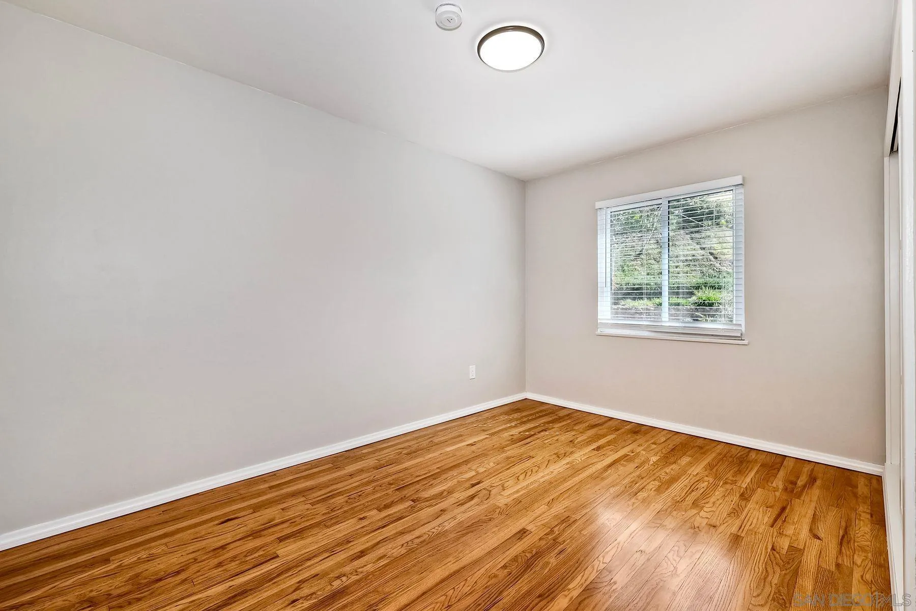 9307 Manor Drive La Mesa, CA 91942 - Photo 15 of 29 an empty room with wooden floor and windows