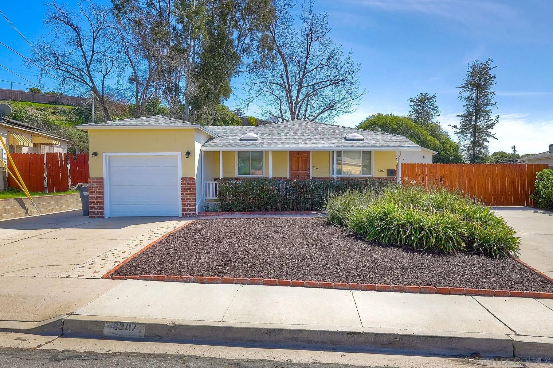 9307 Manor Drive La Mesa, CA 91942 - Photo 2 of 29 a front view of a house with a yard and a garage