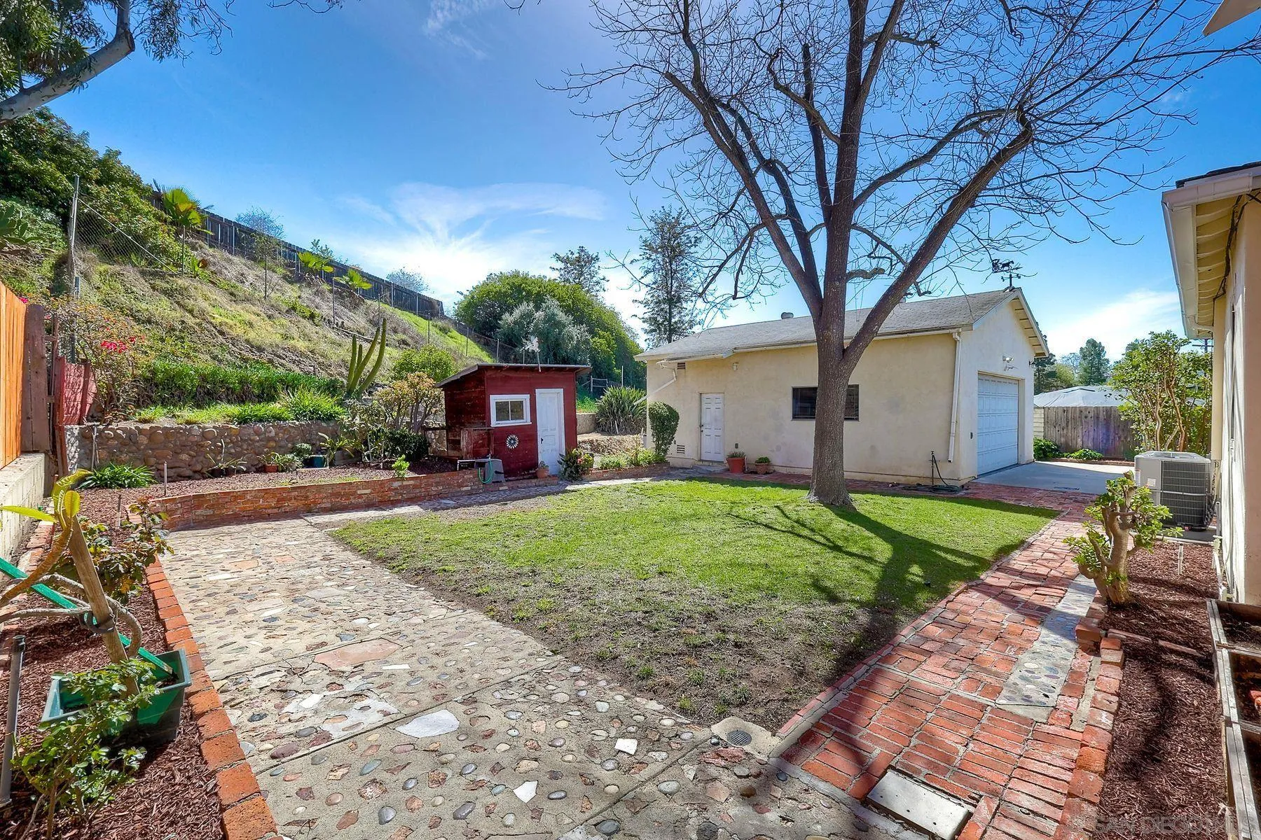 9307 Manor Drive La Mesa, CA 91942 - Photo 29 of 29 a front view of a house with a garden and trees
