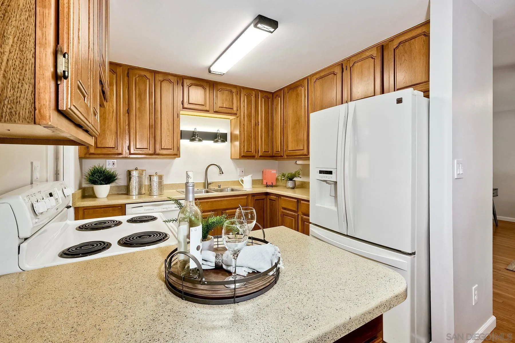 9307 Manor Drive La Mesa, CA 91942 - Photo 9 of 29 a kitchen with stainless steel appliances granite countertop a refrigerator a stove and a dining table with wooden floor