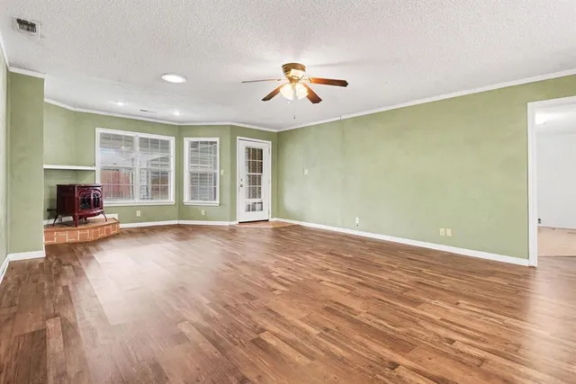 a view of a livingroom with wooden floor and a ceiling fan