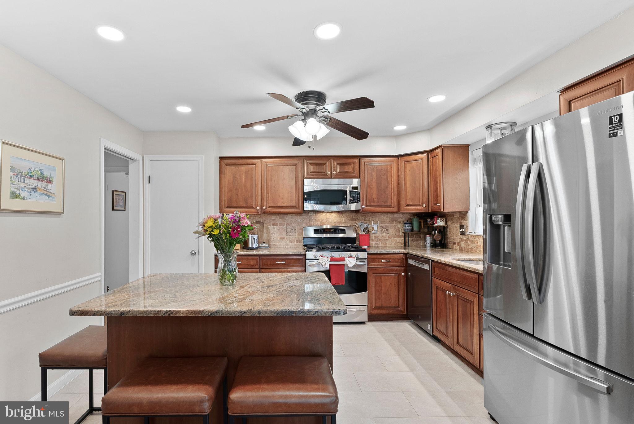 4119 27th Road North Arlington, VA 22207 - Photo 13 of 53 a kitchen with granite countertop a table chairs refrigerator and microwave