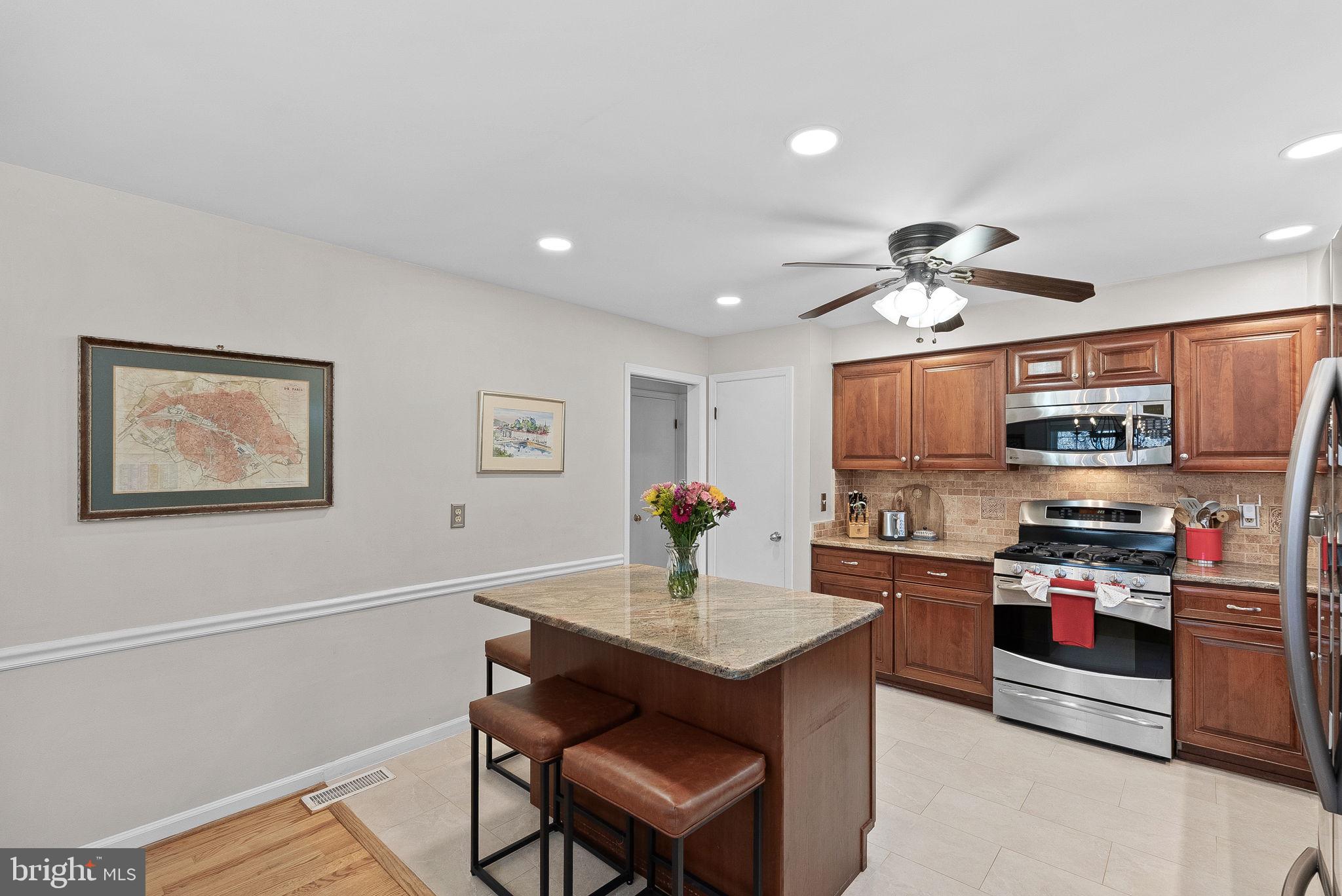 4119 27th Road North Arlington, VA 22207 - Photo 15 of 53 a kitchen with stainless steel appliances a sink a stove a microwave a dining table and chairs