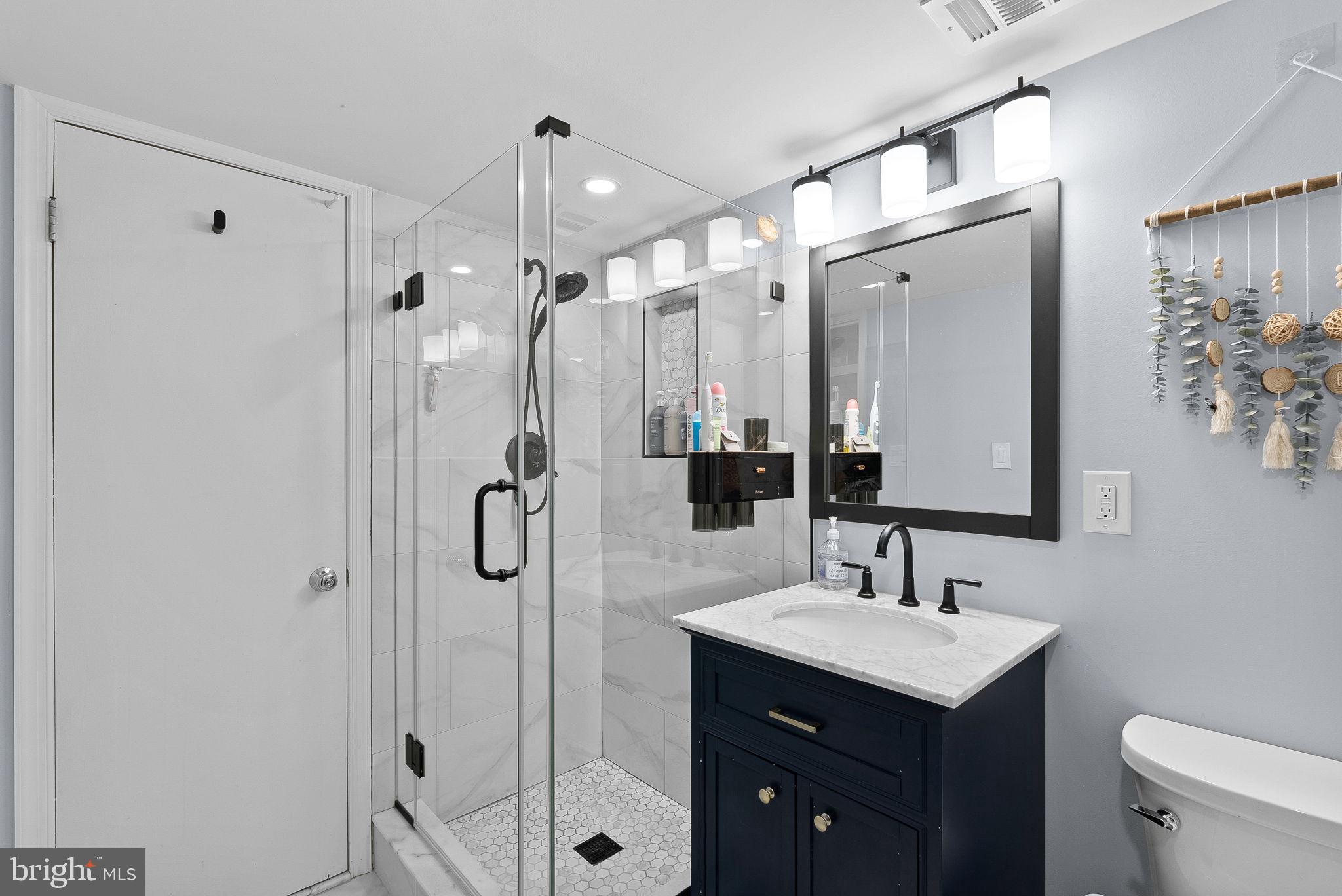 4119 27th Road North Arlington, VA 22207 - Photo 35 of 53 a bathroom with a shower sink vanity and mirror