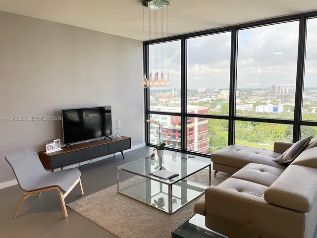 a living room with furniture a flat screen tv and a large window