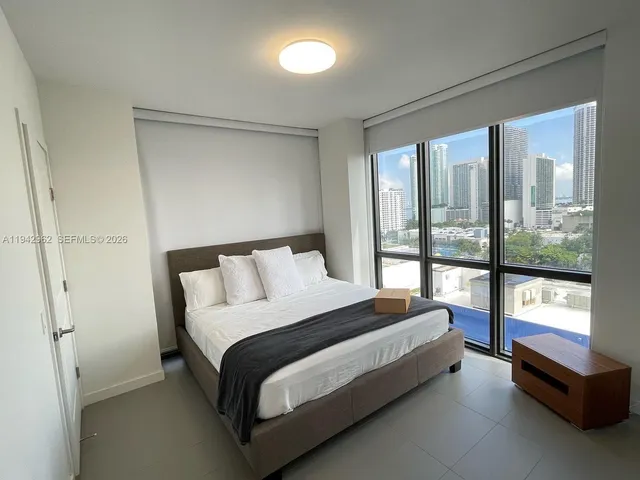 a large bedroom with a bed and glass window