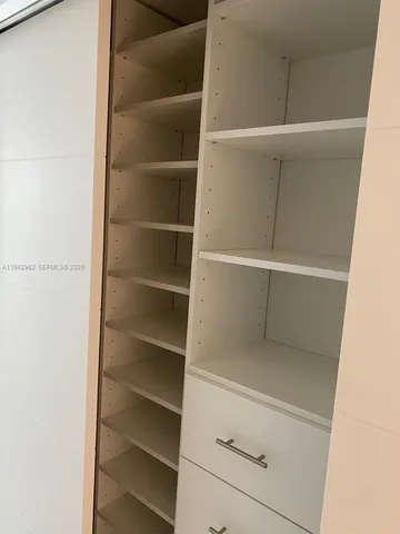 a view of walk in closet with empty racks