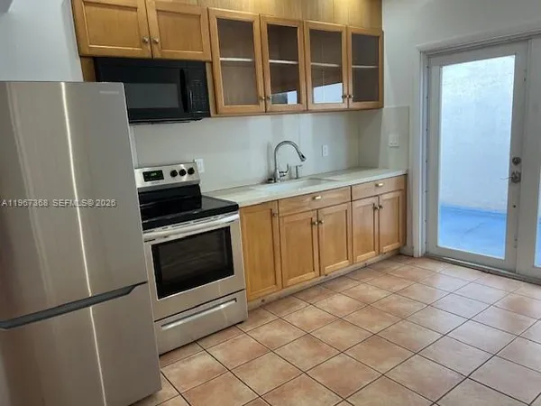 a kitchen with stainless steel appliances granite countertop a refrigerator and a sink