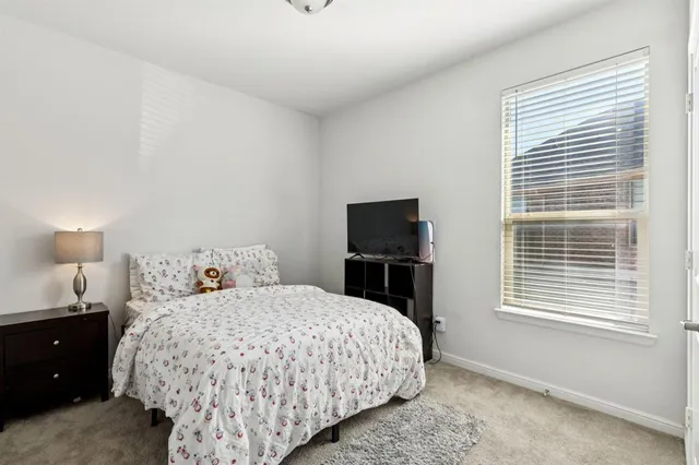 a bedroom with a bed and a tv on the dresser