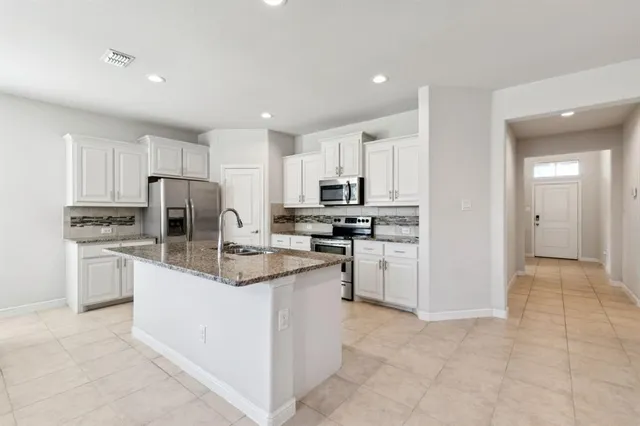 a kitchen with refrigerator and cabinets