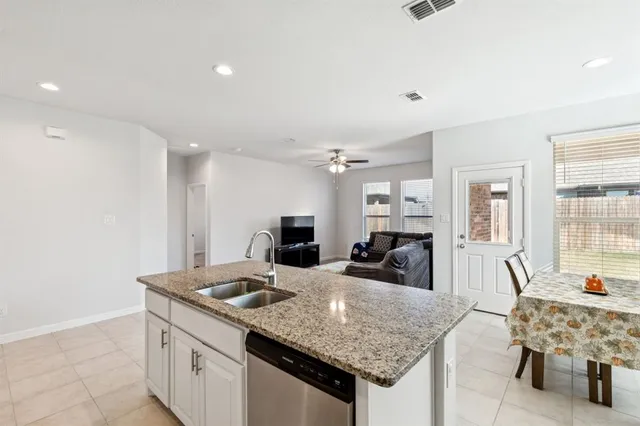 a view of living room kitchen with stainless steel appliances granite countertop furniture and fireplace