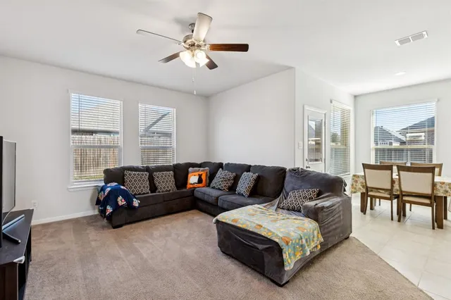 a living room with furniture a table and a large window