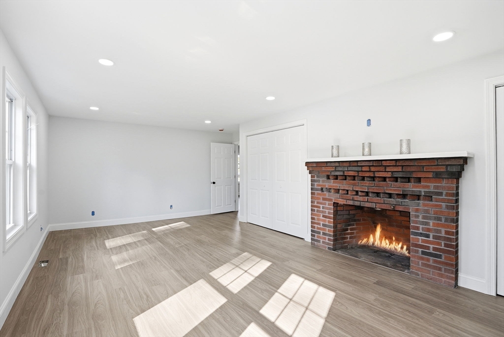 357 Wareham Street Middleboro, MA 02346 - Photo 19 of 42 a view of an empty room with wooden floor fireplace and a window