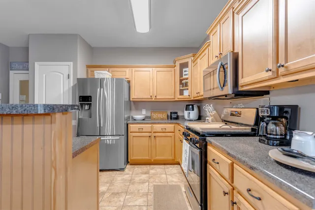 a kitchen with stainless steel appliances granite countertop a refrigerator and a stove