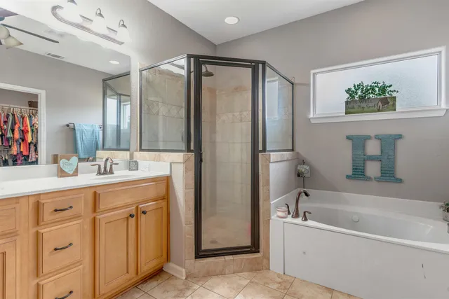 a bathroom with a tub a sink and mirror