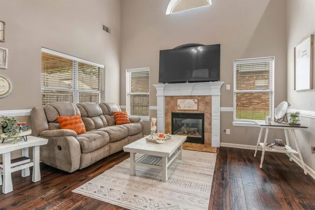 a living room with furniture a flat screen tv and a fireplace