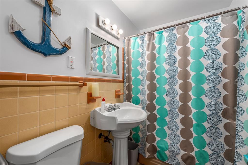 331 Hernando Street, Unit S 123 Fort Pierce, FL 34949 - Photo 15 of 52 a bathroom with a sink a toilet a mirror and shower curtain