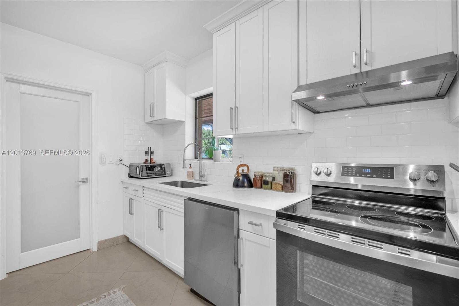 470 Northeast 113th Street, Unit 1 Miami, FL 33161 - Photo 11 of 56 a kitchen with stainless steel appliances granite countertop a sink stove and cabinets