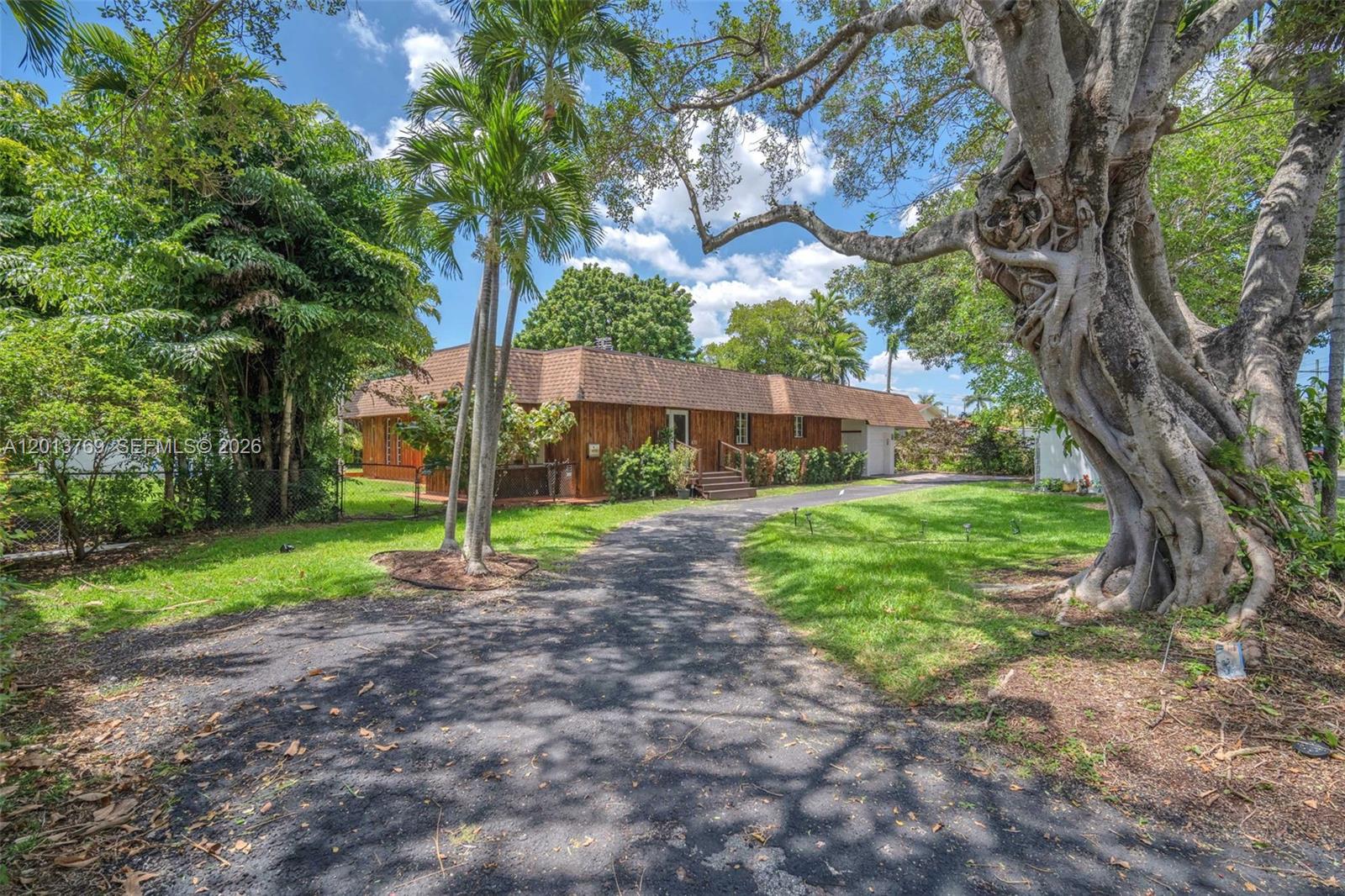 470 Northeast 113th Street, Unit 1 Miami, FL 33161 - Photo 2 of 56 a view of a yard with plants and a large tree