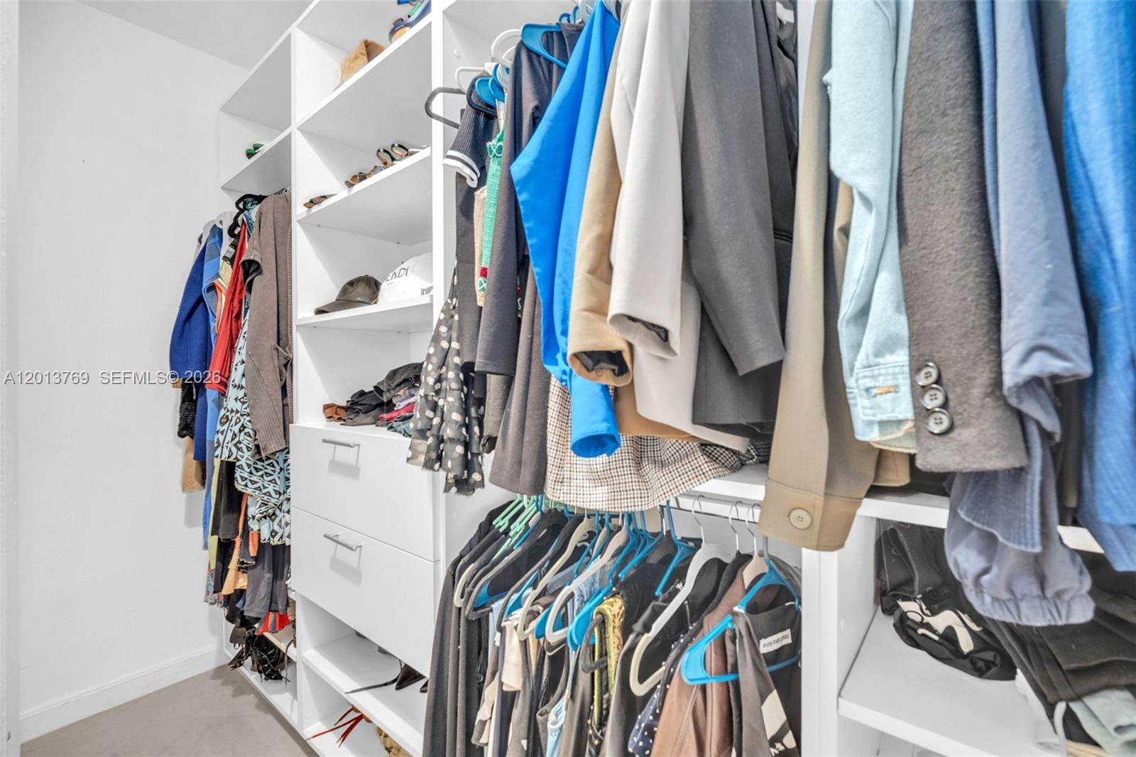 470 Northeast 113th Street, Unit 1 Miami, FL 33161 - Photo 28 of 56 a view of walk in closet with clothes and shoes