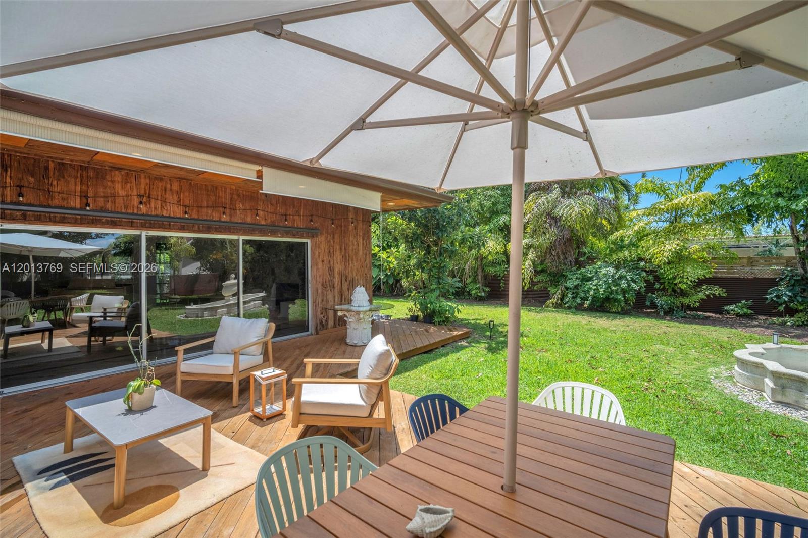 470 Northeast 113th Street, Unit 1 Miami, FL 33161 - Photo 46 of 56 a view of a patio with couches chairs under an umbrella