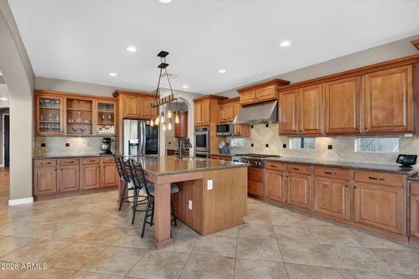 a kitchen with stainless steel appliances granite countertop a stove and a microwave