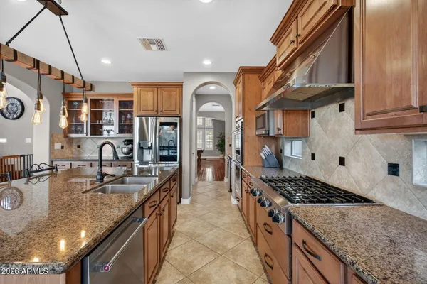 a kitchen with stainless steel appliances granite countertop a refrigerator and a sink