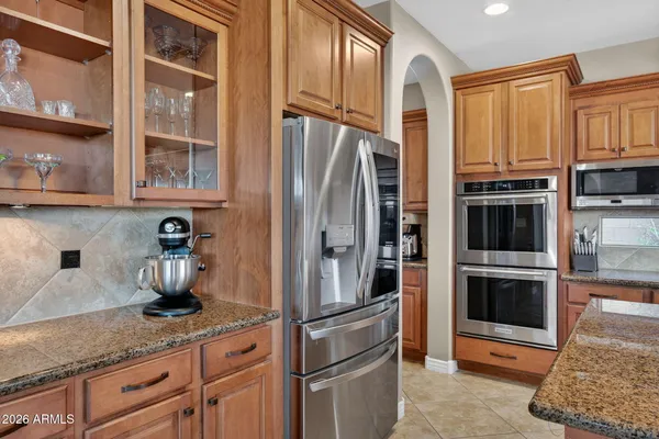 a kitchen with granite countertop a sink a stove and cabinets