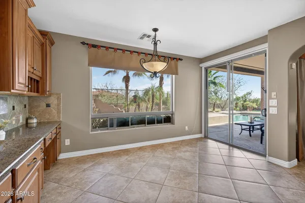 a view of an empty room with window and a kitchen