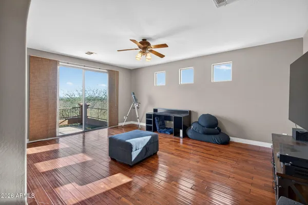 an empty room with windows and chandelier fan