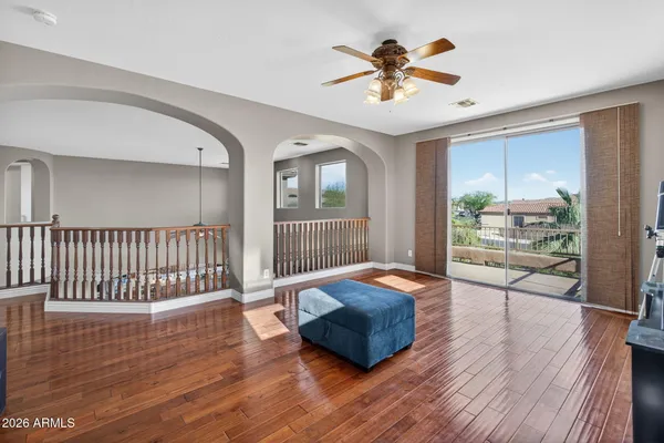 an empty room with windows and chandelier fan