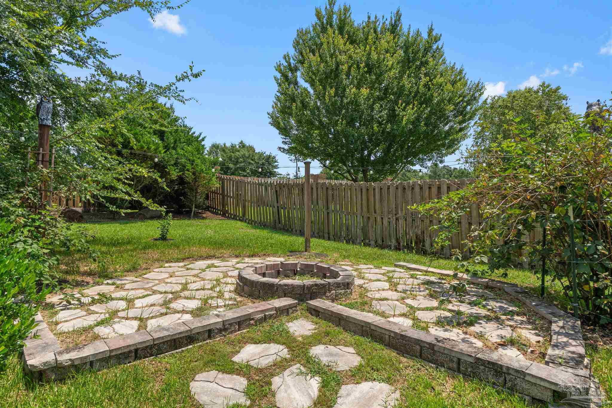 2698 Tulip Hill Road Pace, FL 32571 - Photo 64 of 65 a view of a backyard with a fountain plants and large tree