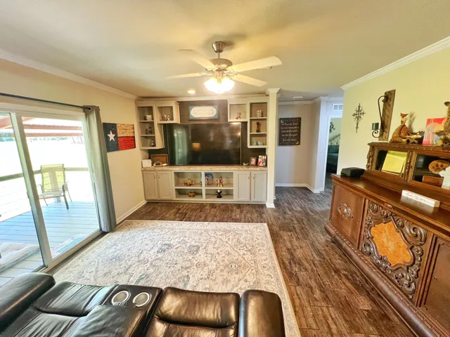 a living room with furniture large window and wooden floor