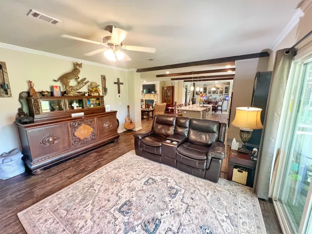 a dining room with furniture a chandelier and wooden floor