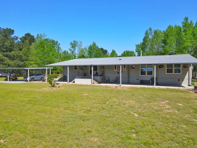 a view of a house with pool and a yard