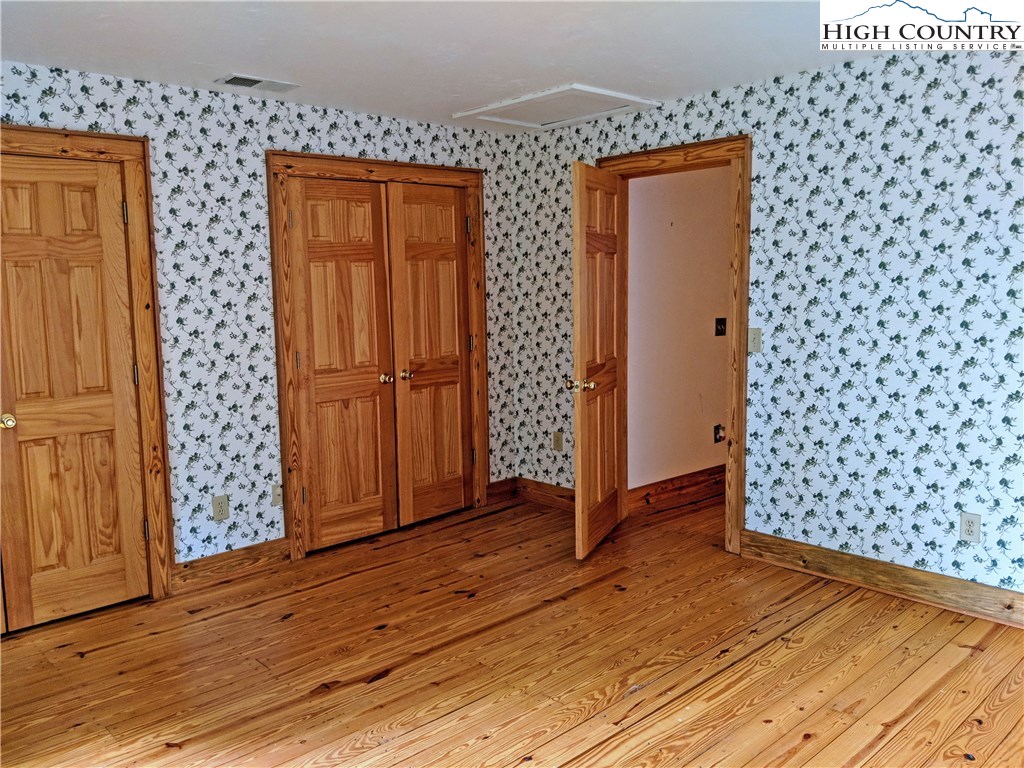 375 Deer Run Road Deep Gap, NC 28618 - Photo 25 of 44 an empty room with wooden floor and door