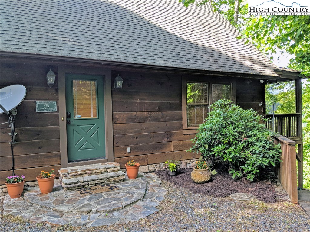 375 Deer Run Road Deep Gap, NC 28618 - Photo 3 of 44 a view of a house with table and chairs and potted plants